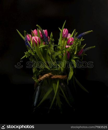 vase with purple dutch tulips still life with black background