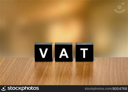 VAT or value added tax on black block with blurred background
