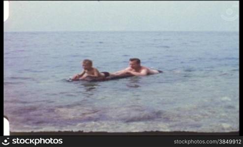 Vater und Sohn schwimmen auf einer Luftmatratze (8 mm-Film)