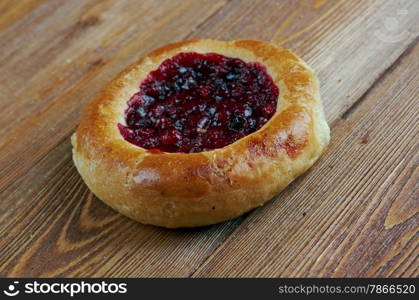 Vatrushkai- patties with cowberry.Russian pastry.on a wood background