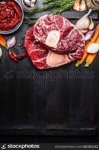 Veal shank slices meat and ingredients for Osso Buco cooking on dark wooden background, top view, vertical border