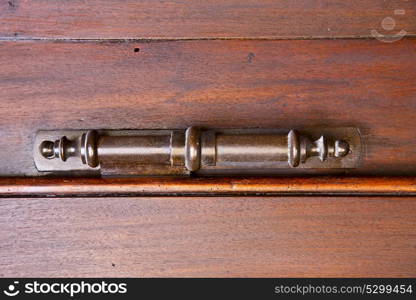 vedano olona abstract rusty brass brown knocker in a door closed wood lombardy italy varese