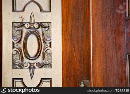 vedano olona varese abstract rusty brass brown knocker in a door curch closed wood lombardy italy