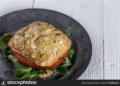 Vegan burger with fresh vegetables on rustic background