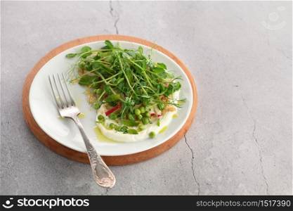 Vegan healthy salad made microgreen sprouts peas, quinoa, radish, mint and yogurt