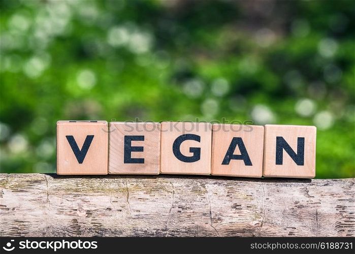 Vegan label on a tree log in a garden