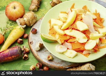 Vegan natural salad with juicy apple, carrot and Jerusalem artichoke.Diet food.. Dietary salad with vegetables and fruits.Vitamin salad