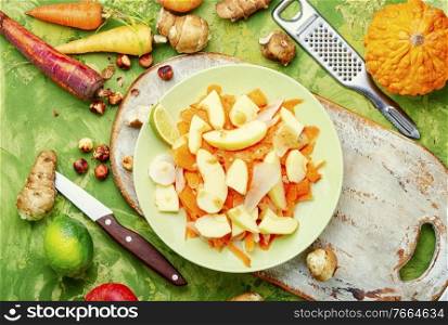 Vegan natural salad with juicy apple, carrot and Jerusalem artichoke.Diet food.. Vitamin salad with vegetables and fruits
