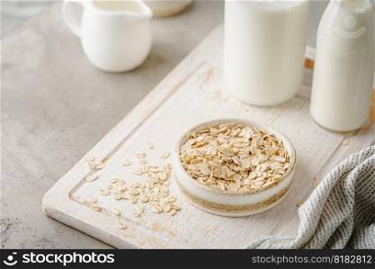 Vegan non dairy alternative milk. Oat flakes milk on stone table. White background. Vegan oat milk.