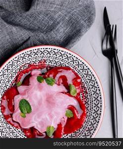 Vegan red ravioli with beetroot on a plate in cream sauce