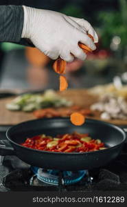 Vegan Restaurant Cooking. Sliced carrots falling into a frying pan, motion blur . Vegan Restaurant Cooking, Falling Sliced Carrot 