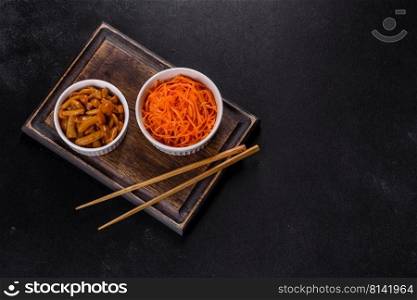 Vegetable appetizer Korean carrots with garlic and pepper and parsley in a bowl on a dark background. Asian, korean carrot salad with spices, olive oil and garlic