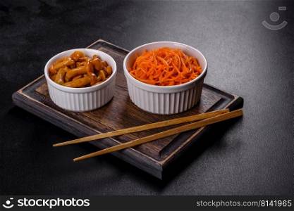 Vegetable appetizer Korean carrots with garlic and pepper and parsley in a bowl on a dark background. Asian, korean carrot salad with spices, olive oil and garlic