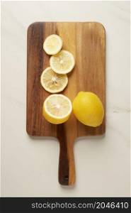 vegetable concept different ranges of thickness of yellow lemon slices being put on the wooden cutting board.