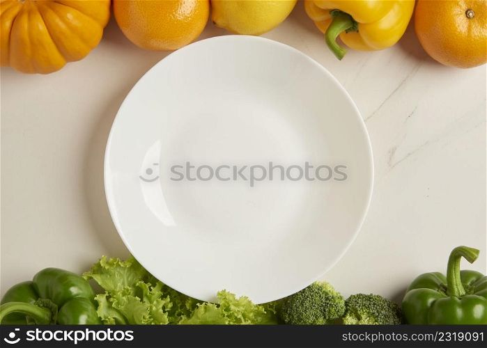 vegetable concept the spotless white plate put on the center of the white background along with various vegetables.