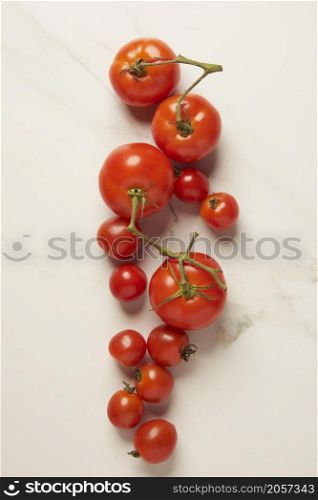vegetable concept various sizes of several red tomatoes being organized on the white background.