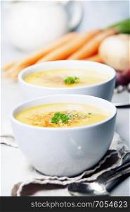 Vegetable cream soup in bowl over grey concrete background, copy space, vertical composition