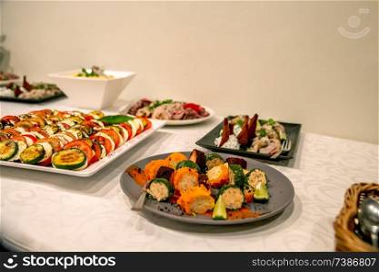 Vegetable dish and other snacks on the festive table in the restaurant. Various vegetable snacks and other appetizers on holiday table. Catering wedding table.