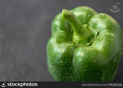 vegetable, food and culinary concept - close up of green pepper on slate stone background. close up of green pepper on slate stone background