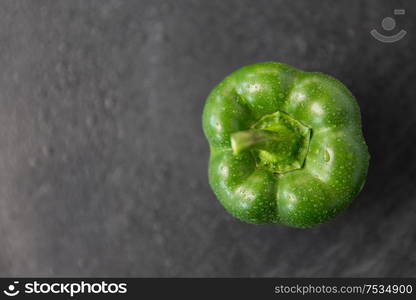 vegetable, food and culinary concept - close up of green pepper on slate stone background. close up of green pepper on slate stone background