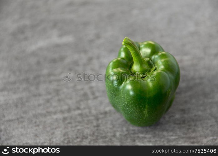 vegetable, food and culinary concept - close up of green pepper on slate stone background. close up of green pepper on slate stone background