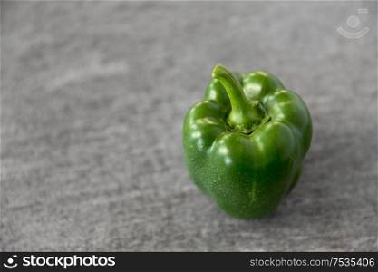 vegetable, food and culinary concept - close up of green pepper on slate stone background. close up of green pepper on slate stone background