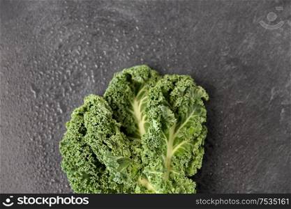 vegetable, food and culinary concept - close up of kale cabbage on slate stone background. close up of kale cabbage on slate background