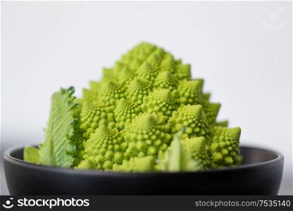 vegetable, food and culinary concept - close up of romanesco broccoli in ceramic bowl. close up of romanesco broccoli in bowl