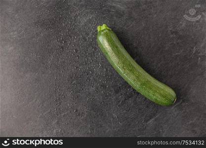 vegetable, food and culinary concept - close up of zucchini on slate stone background. zucchini on slate stone background