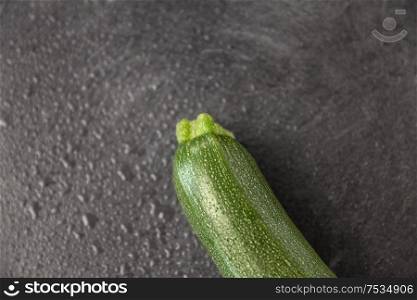 vegetable, food and culinary concept - close up of zucchini on slate stone background. zucchini on slate stone background