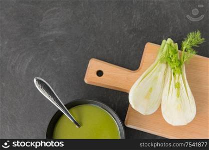 vegetable, food and culinary concept - fennel cream soup in ceramic bowl on slate stone background. fennel cream soup in ceramic bowl