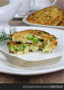 Vegetable fritters of zucchini with peas and herbs