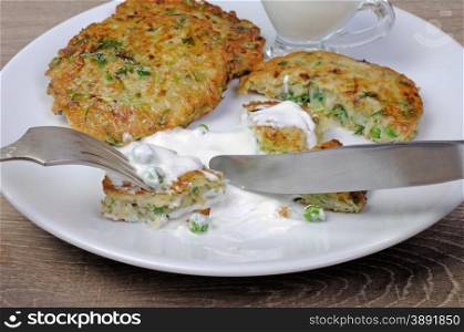 Vegetable fritters of zucchini with peas and herbs