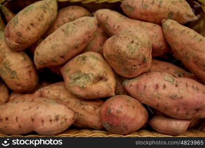 vegetable, harvest, food and sale concept - close up of sweet potatoes in basket