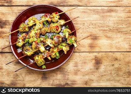 Vegetable kebab from broccoli cabbage on rustic wooden background. Kebab from broccoli cabbage