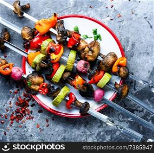 Vegetable kebabs with peppers, mushrooms, zucchini and tomatoes.Vegetarian skewers. Skewers of grilled vegetables