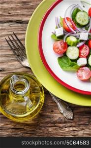 vegetable salad and olive oil. fresh vegetable salad with cucumber,cheese and tomato