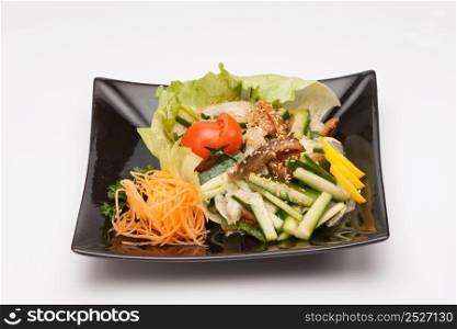 Vegetable salad in black square plate on a light background. vegetable salad in a black plate on a light background
