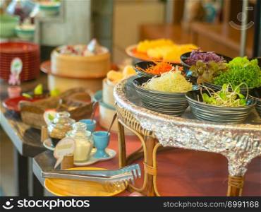 Vegetable salad in bowl in wooden tray with another food for breakfast prepare for guest of hotel.