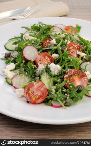 Vegetable salad with arugula, feta ,olive dressing and sesame seeds