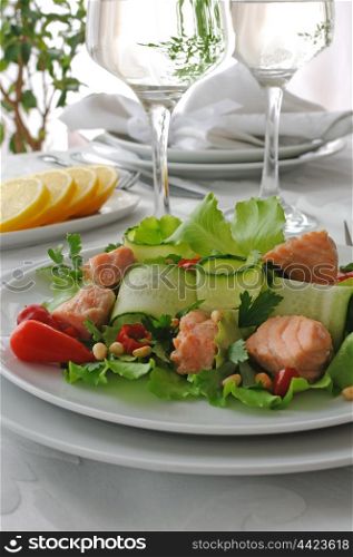 Vegetable salad with boiled salmon and pine nuts
