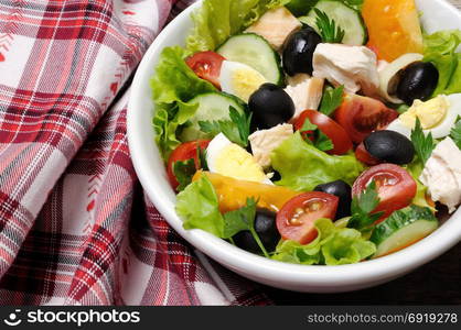 Vegetable salad with chicken and eggs, olives in lettuce leaves. Horizontal shot.