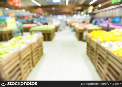 Vegetable section interior in market shop and supermarket with customers as blurred store background