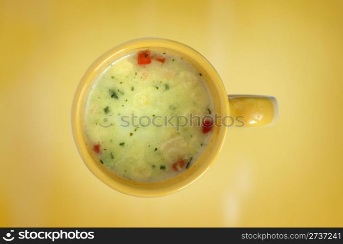 Vegetable soup in a cup. Yellow background