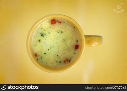 Vegetable soup in a cup. Yellow background