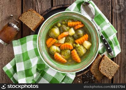 Vegetable soup with brussel sprouts on wooden rustic table, top view