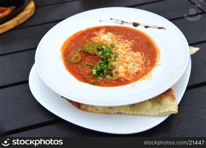 vegetable soup with cheese in white dish