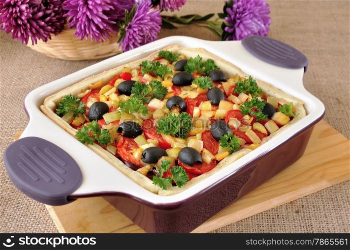 Vegetable tart with olives in a cauldron