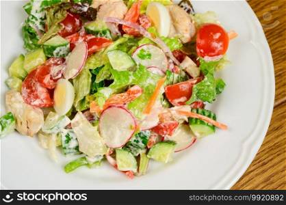 Vegetable vegetarian salad with tomatoes, peppers and onions on wooden table.healthy salad with fresh ripe summer vegetables. Vegetable vegetarian salad with tomatoes, peppers and onions on wooden table.
