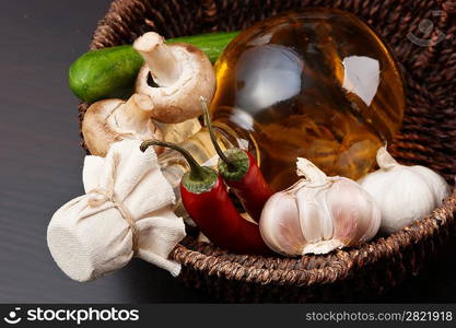 vegetables and a basket with a bottle of vinegar